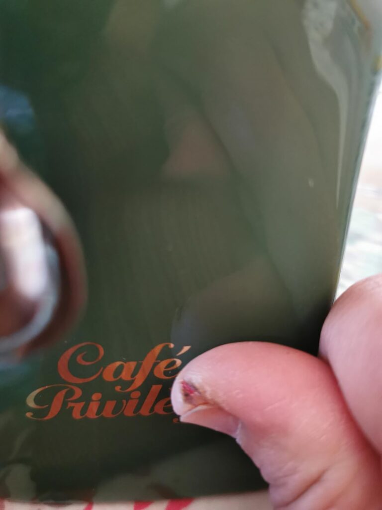 Gros plan sur le logo "Café Privilège" sur le côté d'une tasse en céramique.