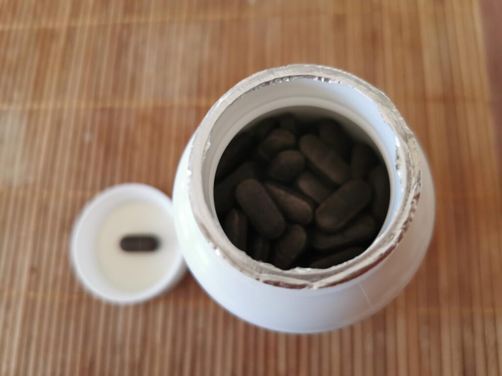 Gros plan de la bouteille de compléments alimentaires ouverte, montrant les gélules à l'intérieur.