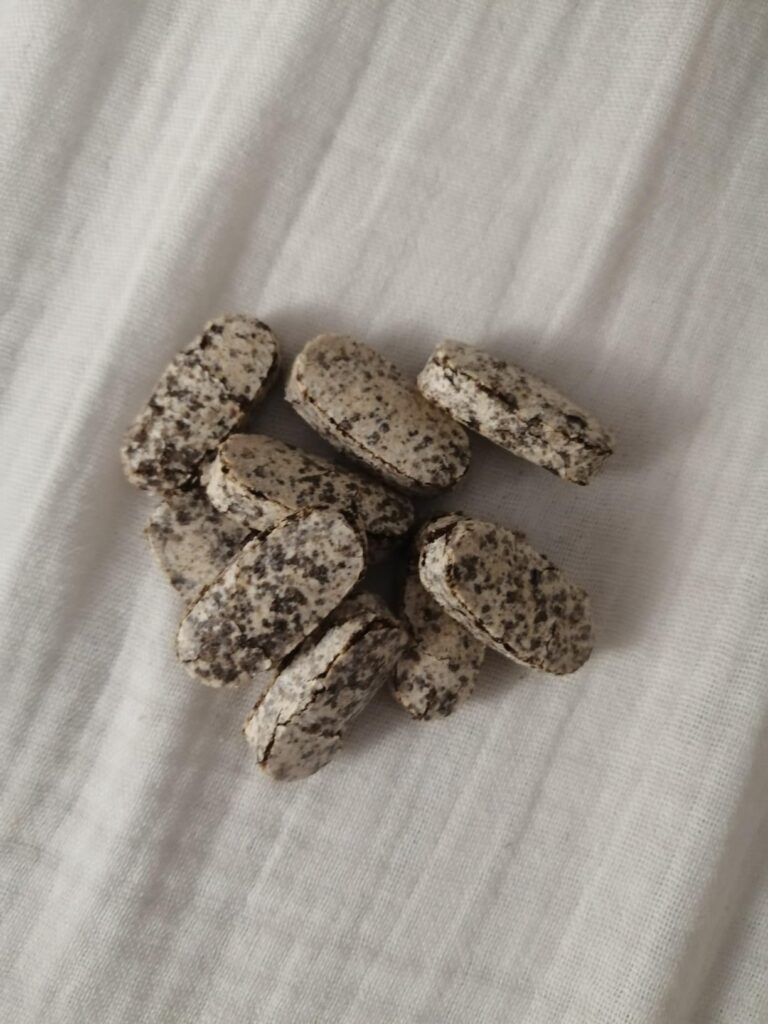 Vue rapprochée de plusieurs comprimés, posés en vrac sur un tissu blanc.