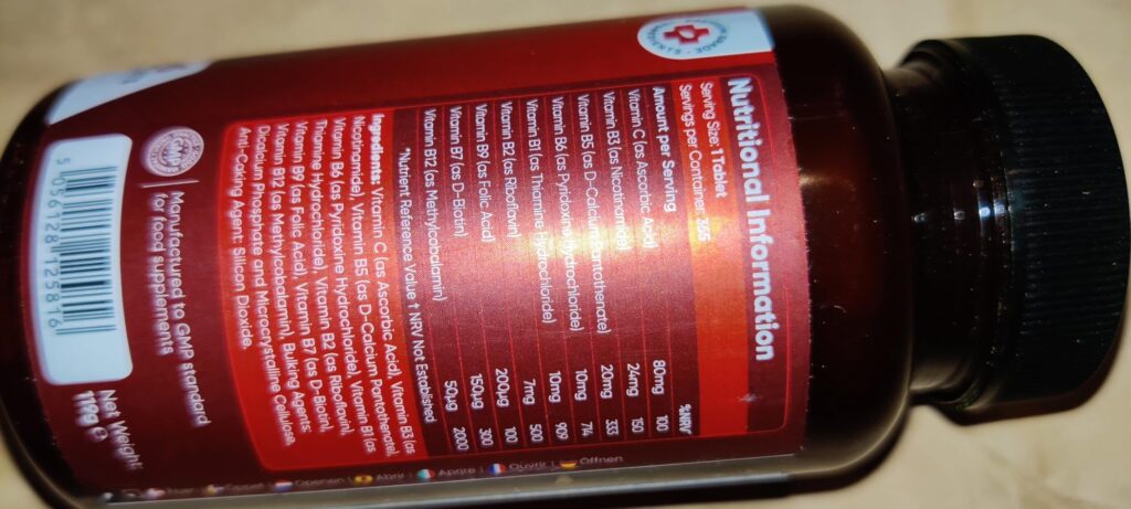 Flacon de complément alimentaire Vitamin B Complex, vue de côté, sur fond clair. L'image est floue et penchée. Un tableau d'i...