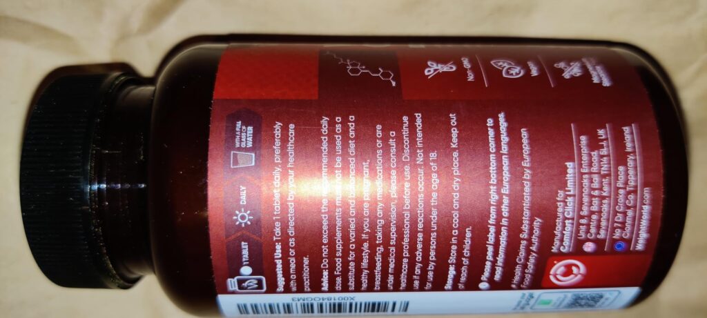 Flacon de complément alimentaire Vitamin B Complex, vue de dos, sur fond clair. L'image est floue et penchée. Des icônes et d...