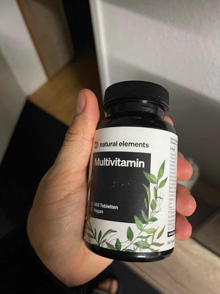 Main tenant le flacon de multivitamines.