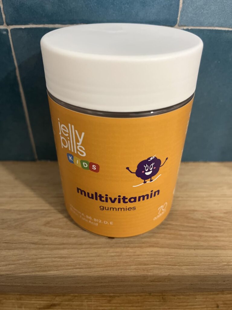 Le pot de vitamines en gros plan sur une étagère en bois.