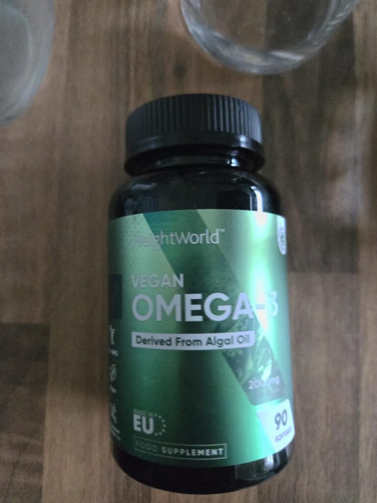 Bouteille d'oméga-3 végétale posée sur une table, vue de dessus.