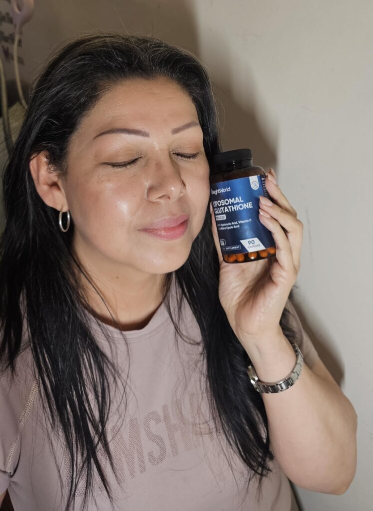 Même femme que le visuel 0, présentant le produit (bouteille de compléments alimentaires), les yeux fermés, le produit près d...