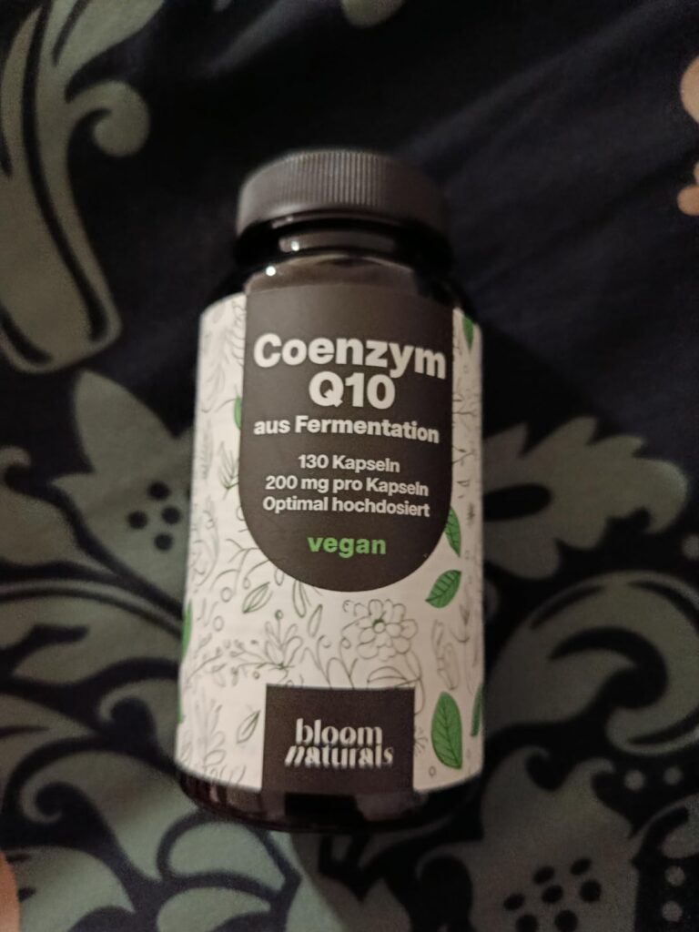 Bouteille de compléments alimentaires posée sur un tissu sombre, vue d'en haut. L'étiquette est bien visible.