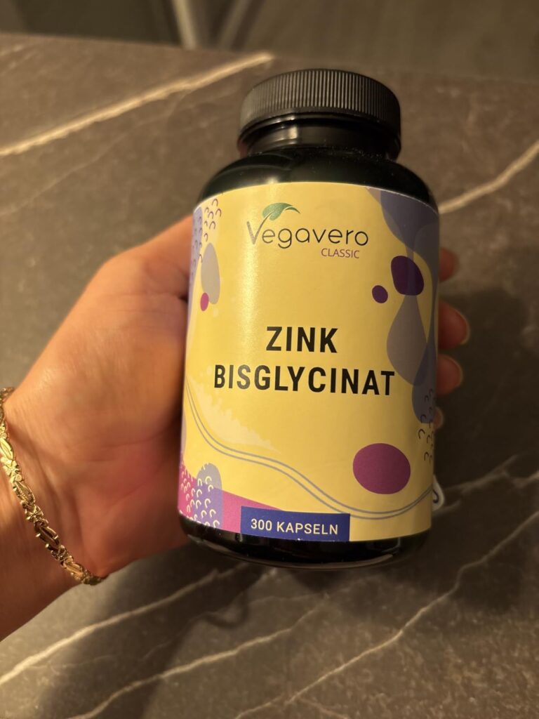 Le flacon de zinc bisglycinat dans la main d'une personne.