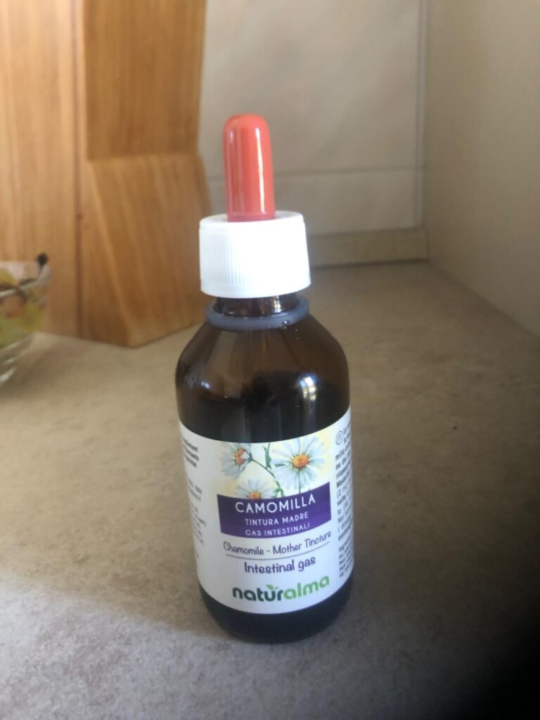 Bouteille de teinture mère de camomille avec pipette, posée sur un plan de travail.