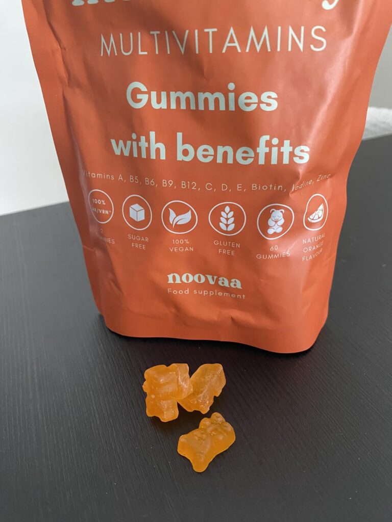 Sachet de compléments alimentaires Noovaa, multivitaminés pour l'immunité, saveur orange. Trois gummies sont devant le sachet...