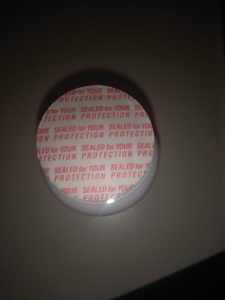 Le dessus du pot avec le sceau de protection intact, vu de près.