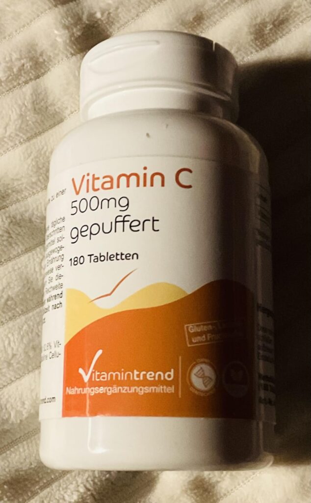 Flacon de vitamine C, similaire au visuel précédent mais avec un éclairage différent.