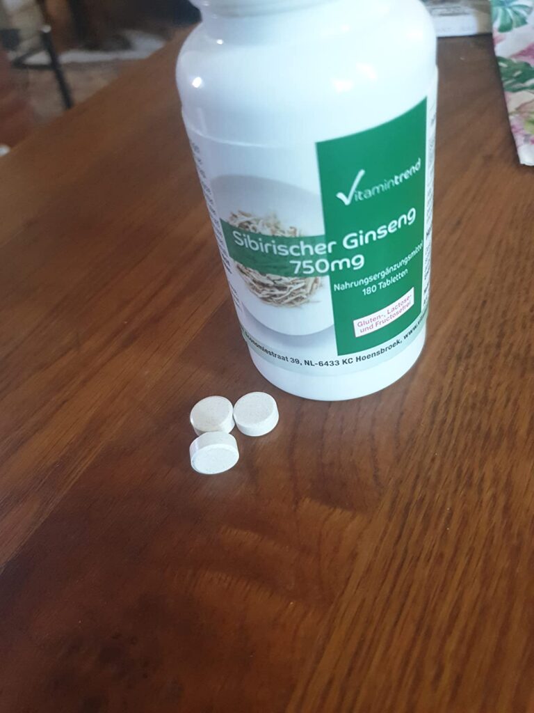 Bouteille de gélules de Ginseng sibérien de marque V-ganic-brand, avec trois gélules posées devant elle.