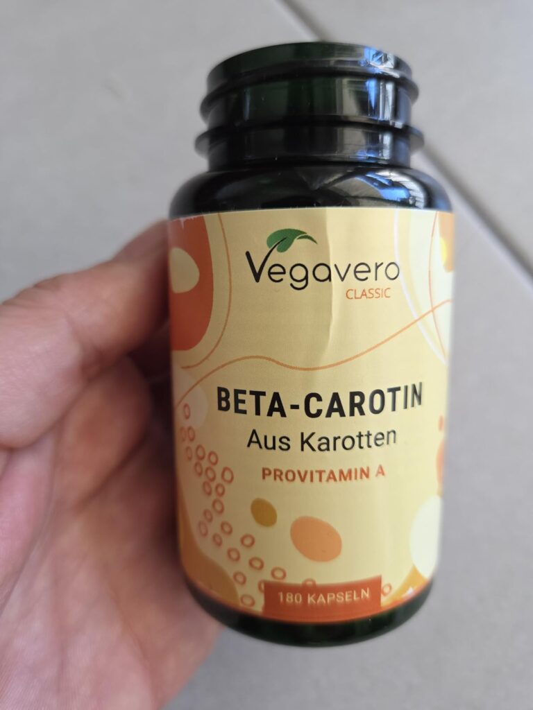 Flacon de béta-carotène tenu dans une main. L'étiquette est bien visible.