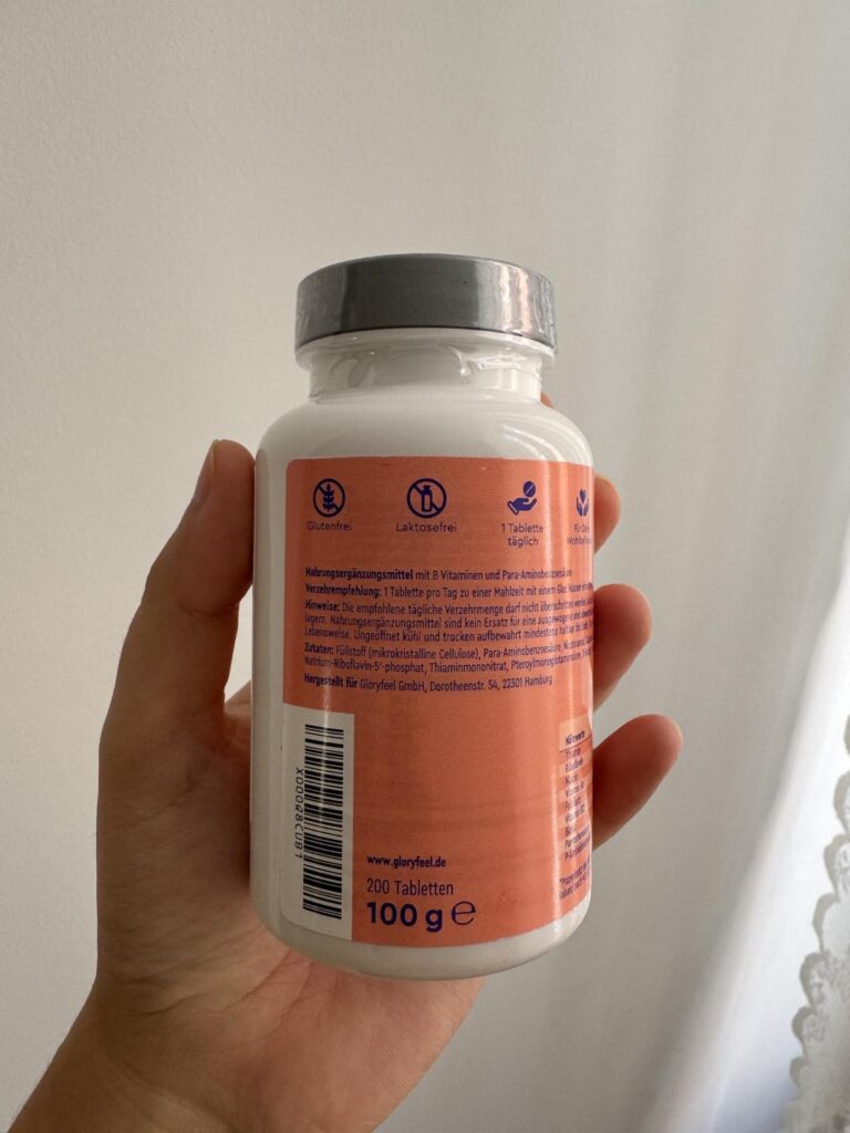Une main tient le flacon, montrant le côté arrière, avec les informations nutritionnelles. Similaire à l'image 0 mais tenue p...