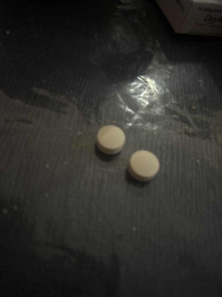 Deux pilules sur un fond sombre.