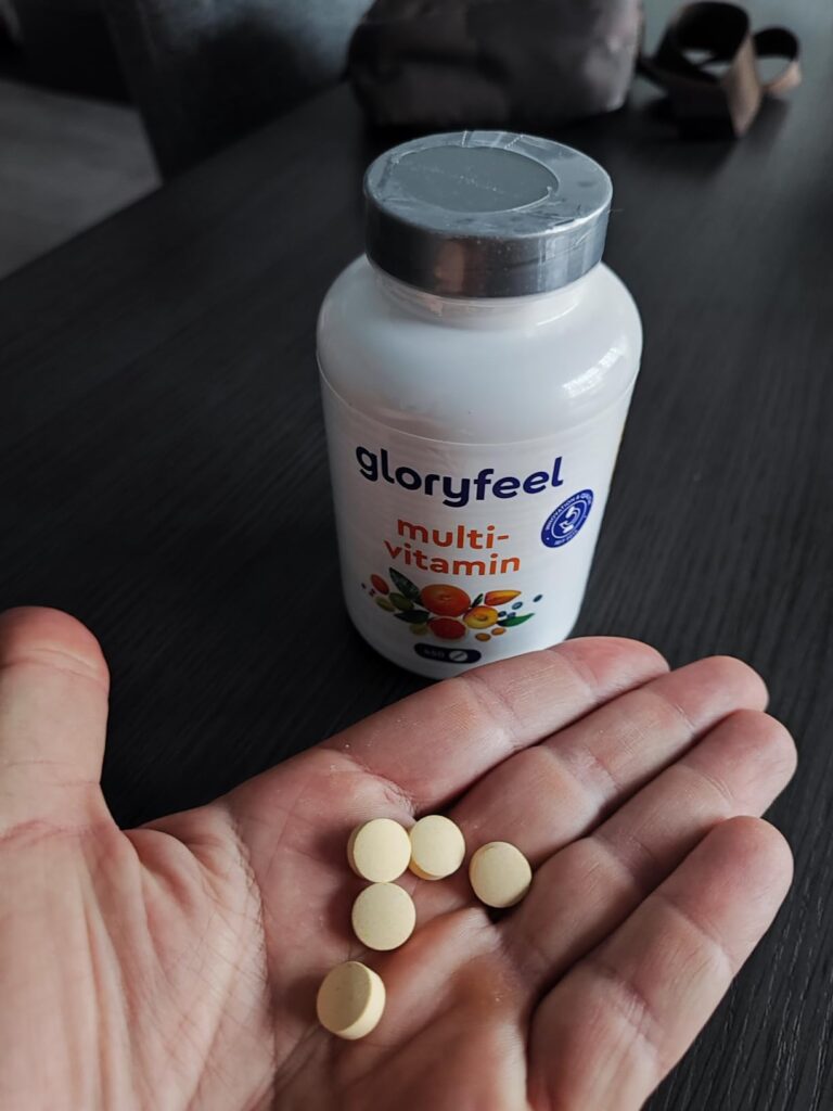 La bouteille de pilules et cinq pilules dans la paume d'une main.