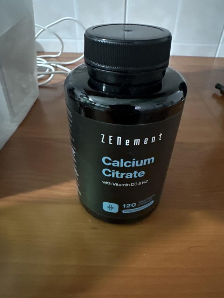 Bouteille de Calcium Citrate noire fermée, sur une table en bois.