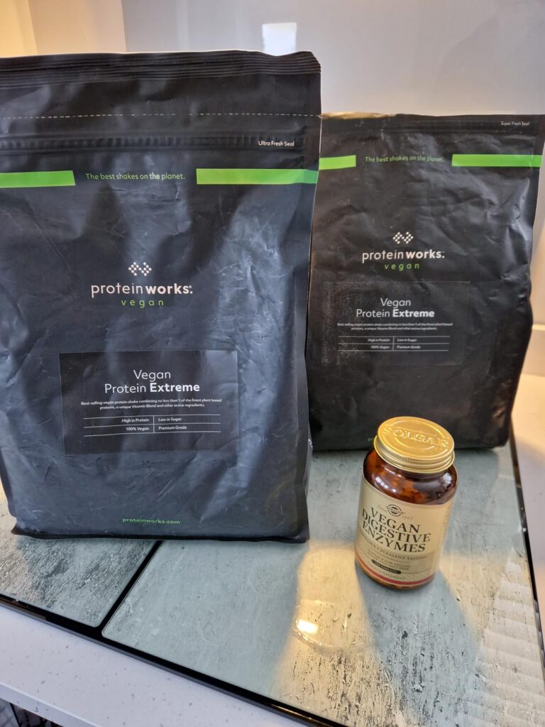 Deux sachets de Vegan Protein Extreme et un pot de Vegan Digestive Enzymes sur une table.