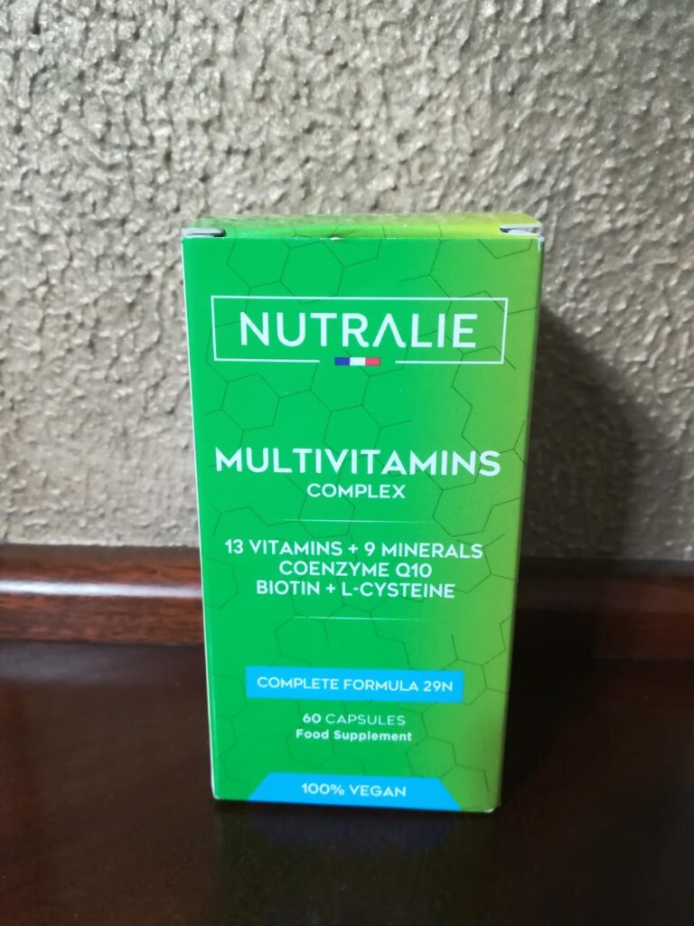 Boîte d'emballage du produit, posée sur une surface en bois. Texte visible sur la face avant.