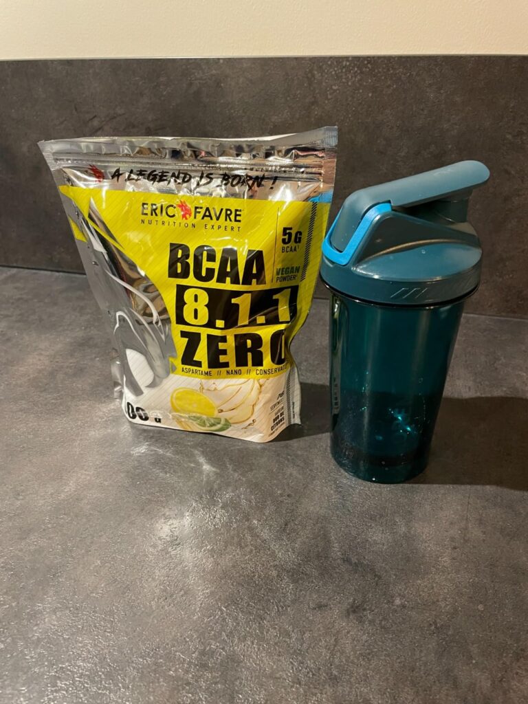 Le sachet de BCAA et un shaker sur un plan de travail.