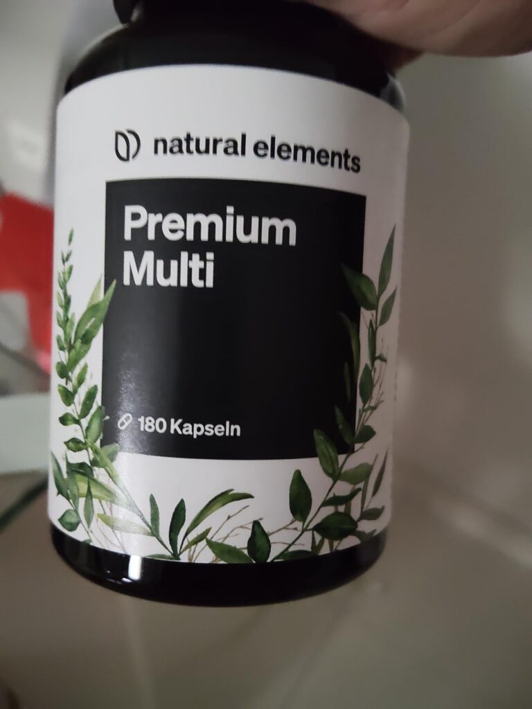 Gros plan sur l'étiquette du flacon de compléments alimentaires, tenu dans la main.