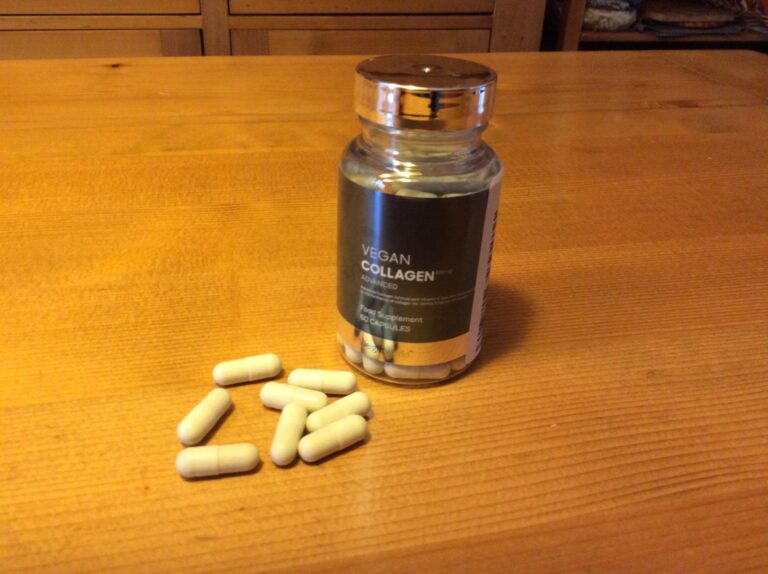 Un flacon de compléments alimentaires 'Vegan Collagen Advanced' et plusieurs capsules de ce même produit sont posés sur une t...