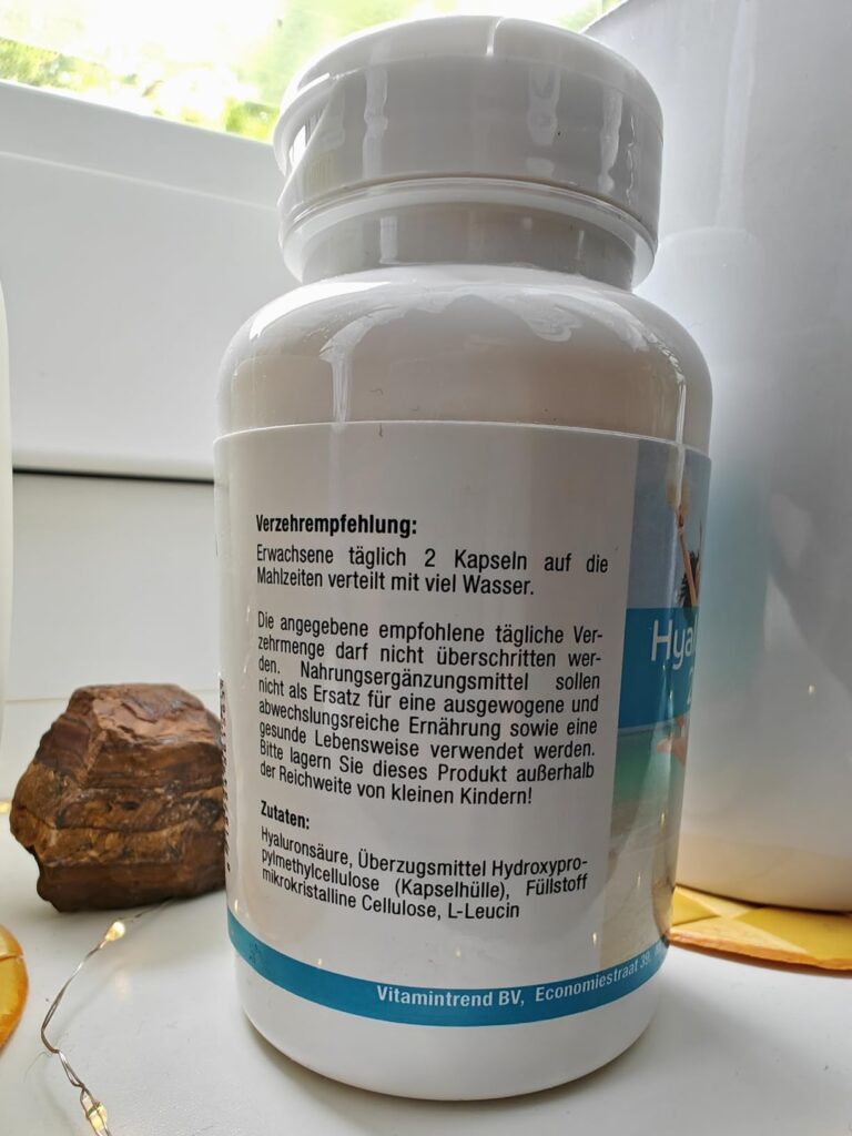 Bouteille de complément alimentaire sur un rebord de fenêtre, vue de dos avec l'étiquette affichant les conseils d'utilisatio...