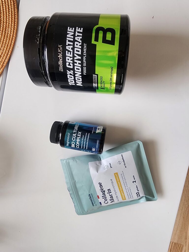 Le flacon de compléments alimentaires posé sur une table, à côté d'autres produits de nutrition sportive.