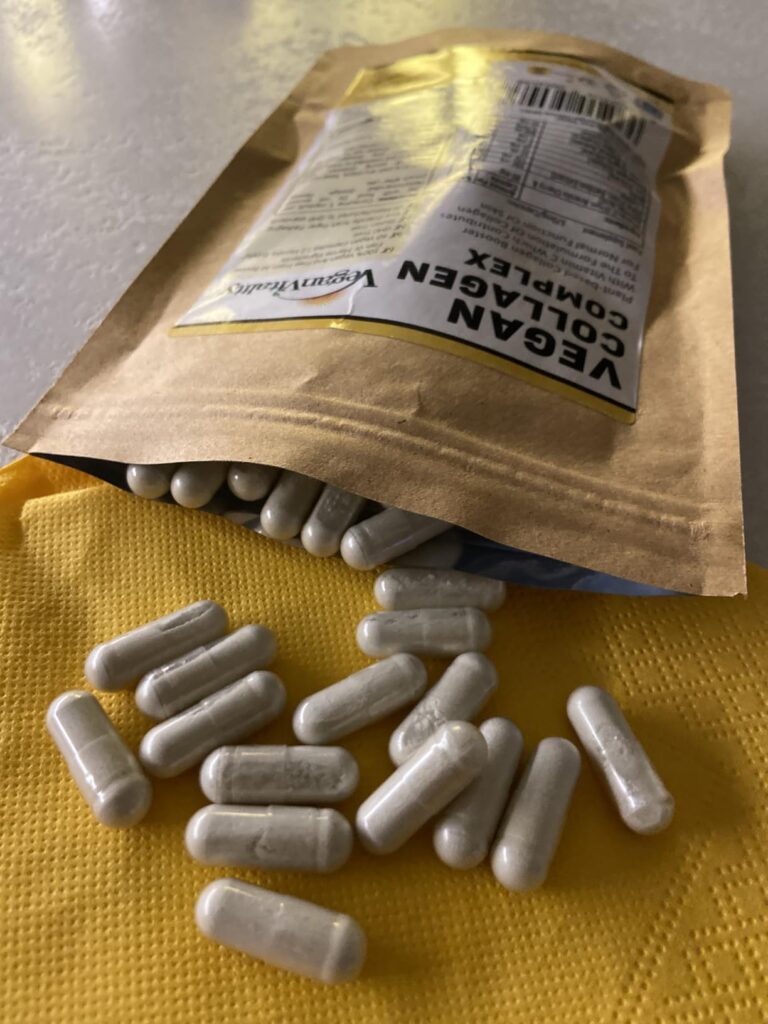 Le sachet de collagène végétalien posé sur un plan de travail, avec des capsules de collagène étalées devant.