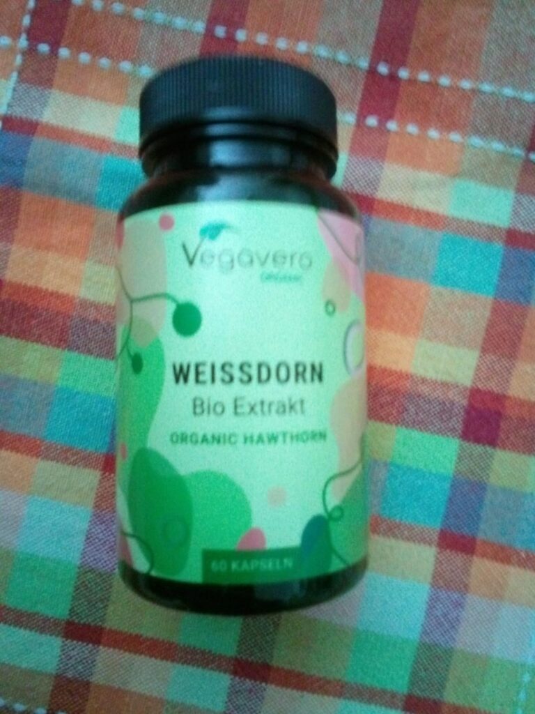 flacon de complément alimentaire Vegavaro Organic Weissdorn Bio Extrakt sur fond de tissu à carreaux