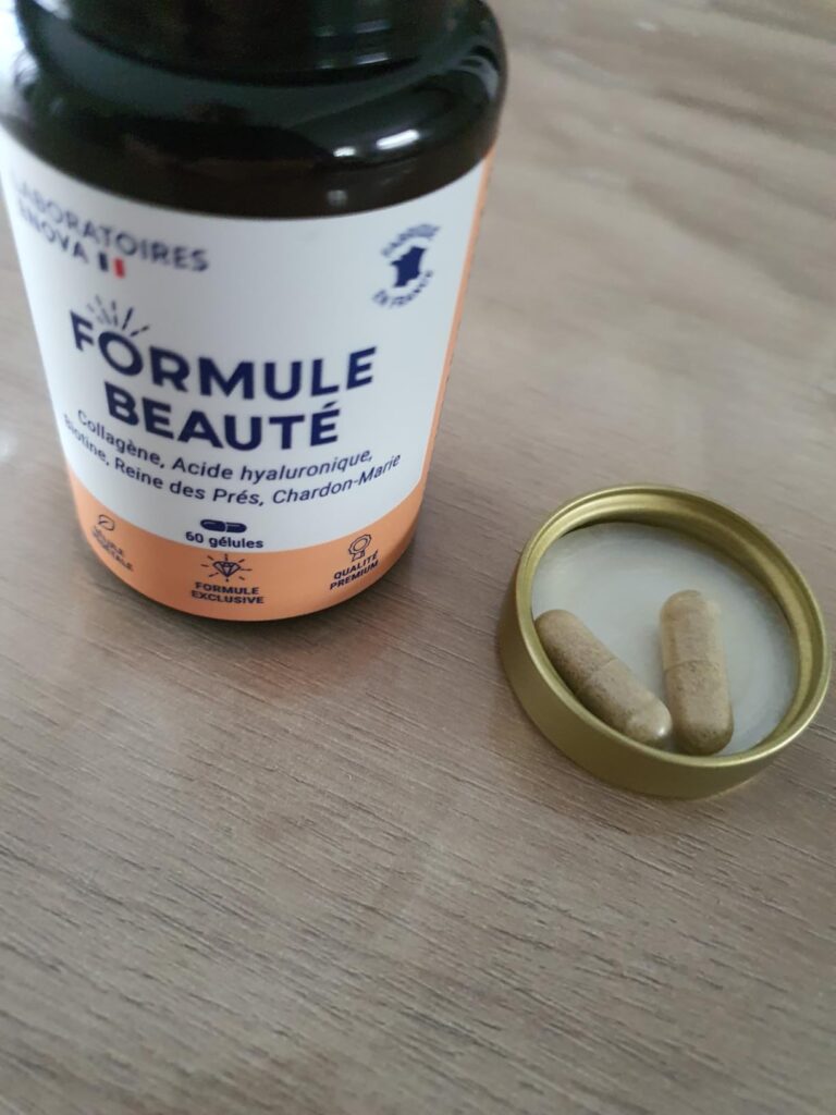 Flacon de complément alimentaire posé sur une table, avec le couvercle ouvert à côté, montrant deux gélules.