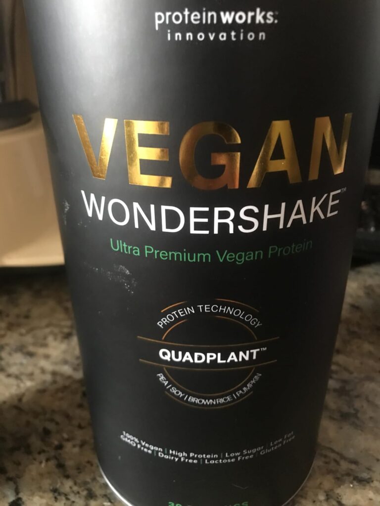 Gros plan sur l'étiquette du pot de "Vegan Wondershake", montrant les détails et le nom du produit. L'image est un gros plan...