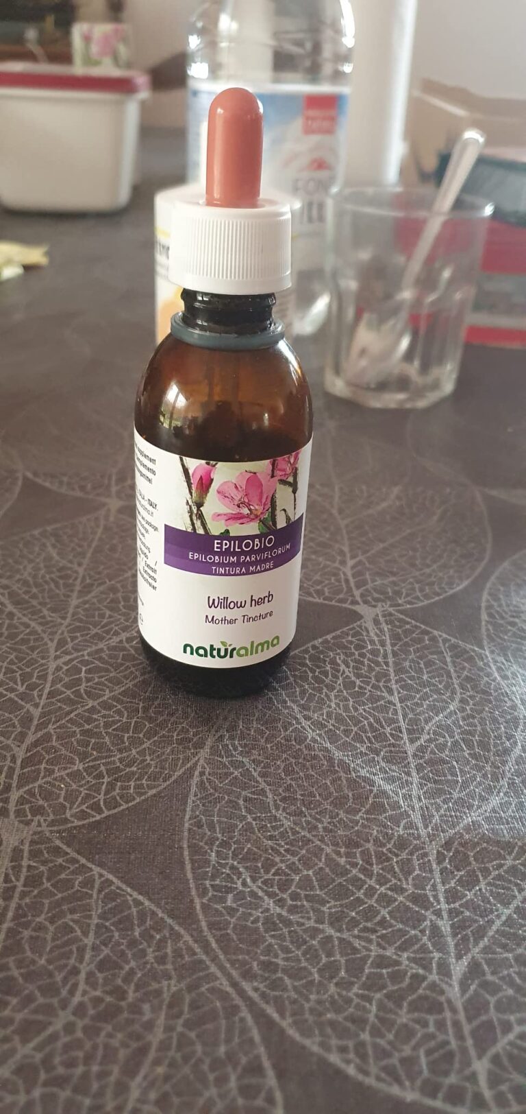 Le flacon de teinture mère posé sur une table, dans un intérieur.