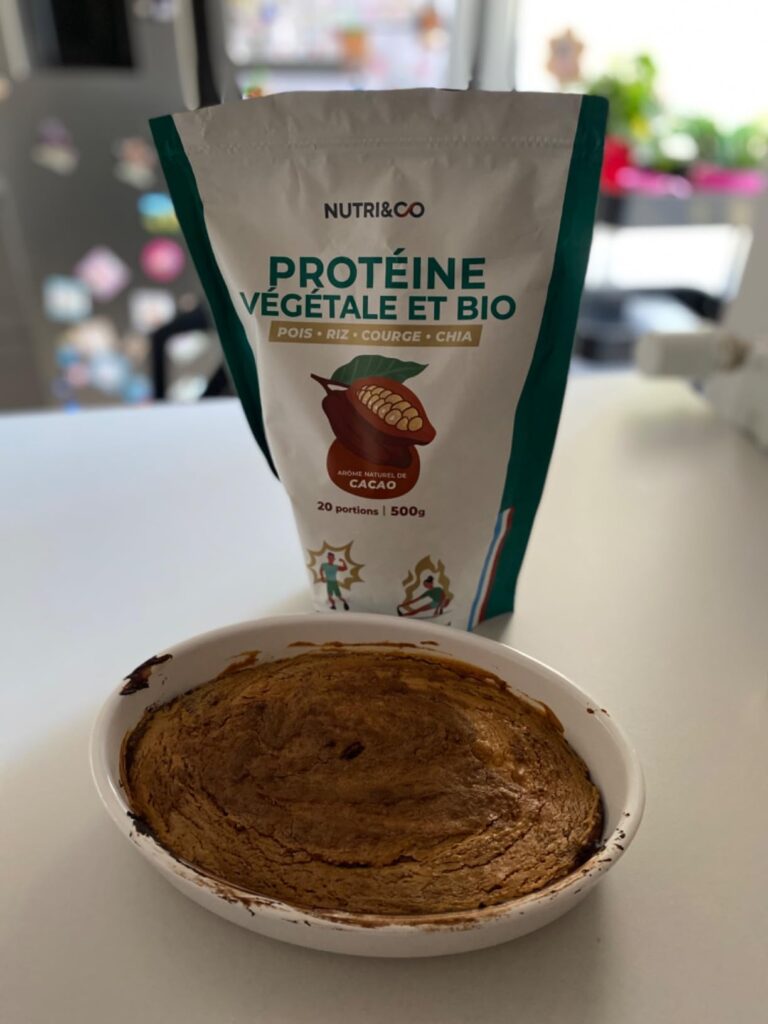 Le sachet de protéines végétales Nutri&Co posé sur une table de cuisine à côté d'un plat cuisiné (peut-être un gâteau) dans u...
