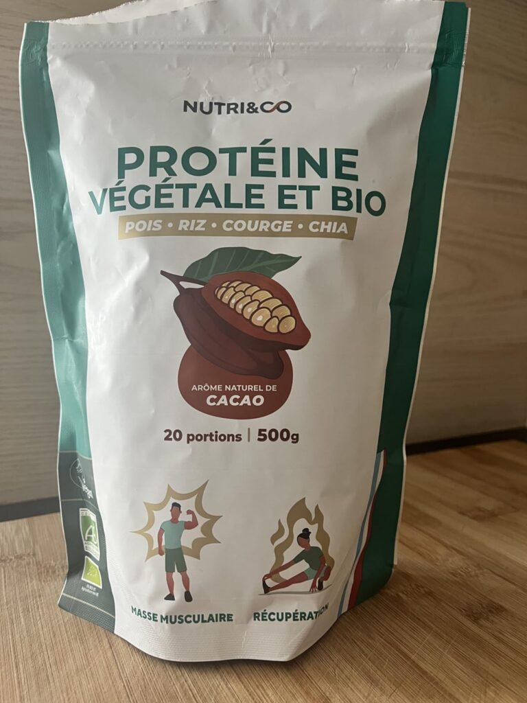 Le sachet de protéines végétales Nutri&Co posé sur une table en bois. Vue du sachet montrant les informations principales et...