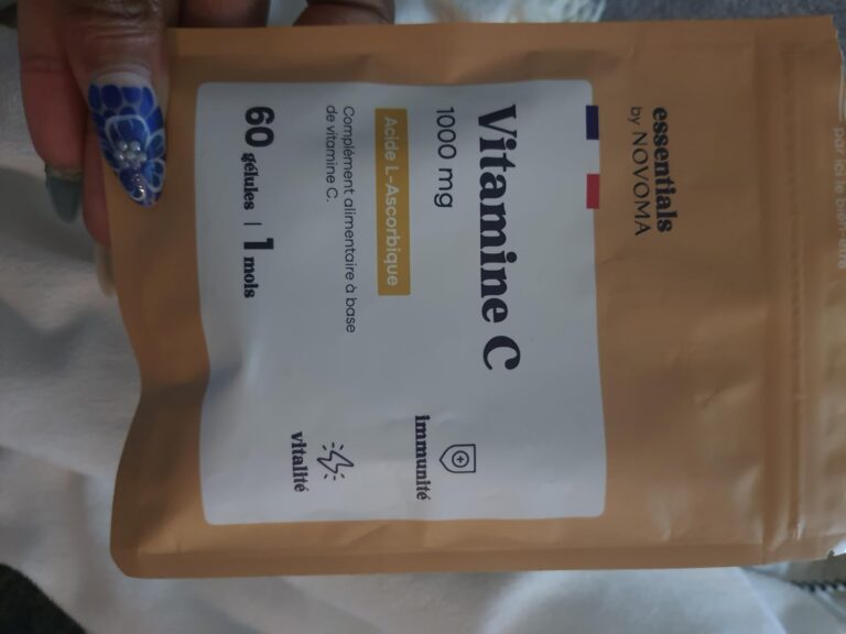 Vue d'ensemble du sachet de vitamines C sur un fond uni, légèrement de biais, une main tenant le sachet.