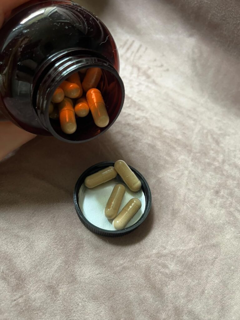 Plusieurs capsules versées dans le bouchon du flacon.