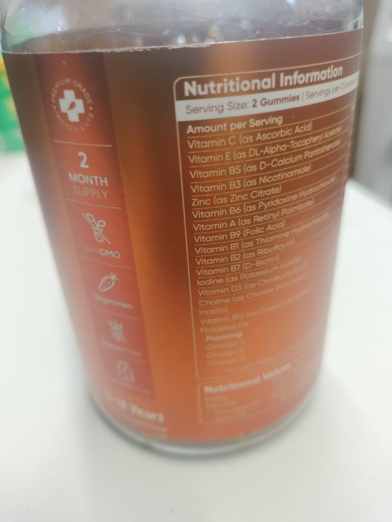 Vue partielle de l'arrière de la bouteille, montrant une partie des informations nutritionnelles et des pictogrammes.