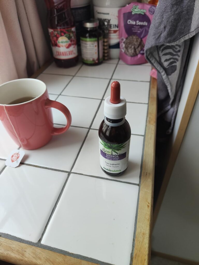 Flacon compte-gouttes pos

sur un carrelage,

avec une tasse de th

en arri

re-plan.