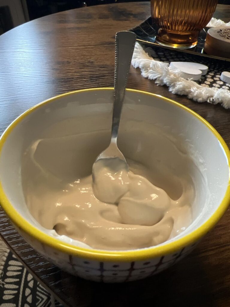 Un bol de préparation de complément alimentaire mélangé avec une cuillère posée dedans.