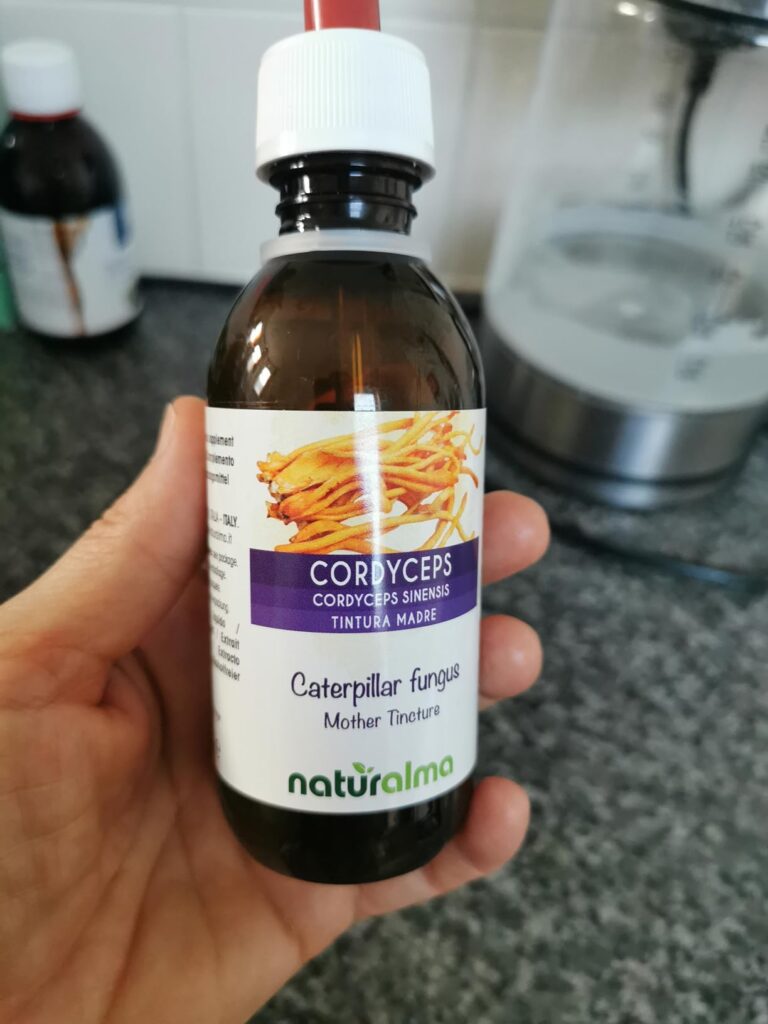 Bouteille de Cordyceps en main dans une cuisine