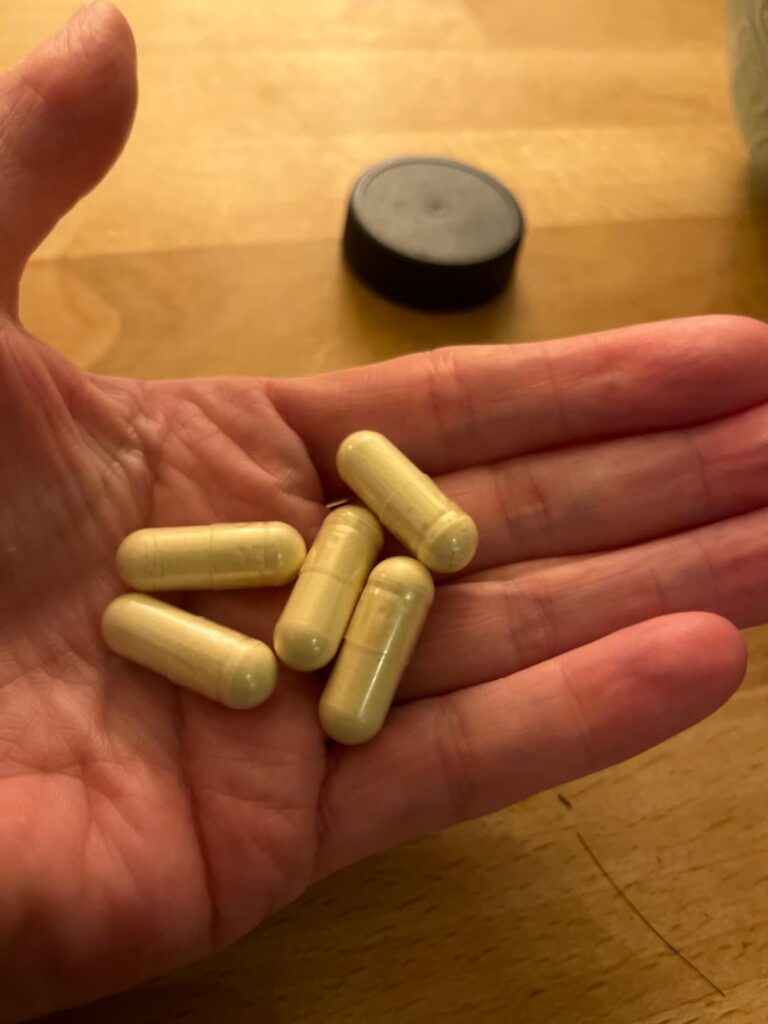 Une main ouverte avec plusieurs gélules de Trans-Resveratrol.