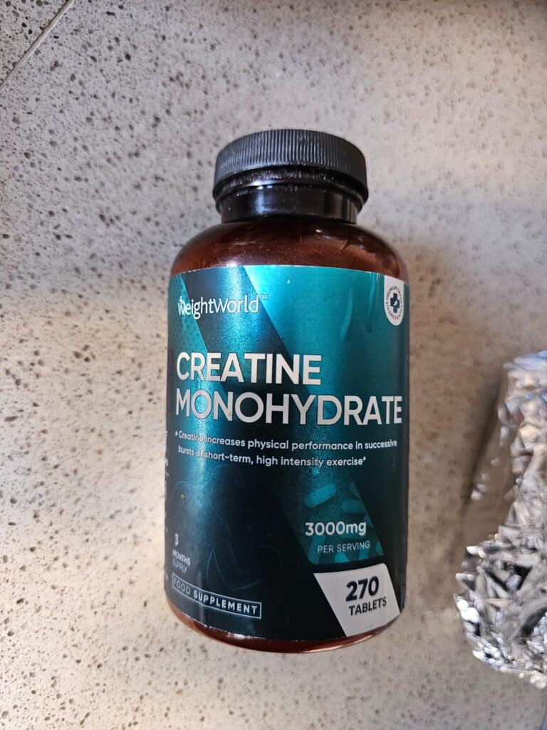Bouteille de créatine monohydrate posée sur un plan de travail, prise de face, similaire au visuel 1.
