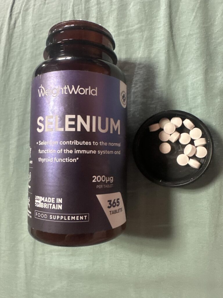 Bouteille de sélénium posée sur une surface verte, avec le couvercle ouvert contenant plusieurs comprimés blancs. Le produit...