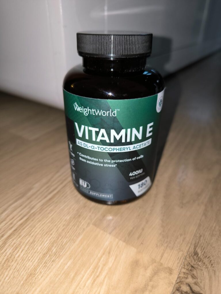 Flacon de vitamine E sur fond de parquet, avec la face avant visible
