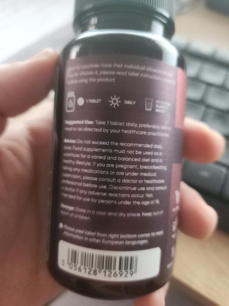 Gros plan sur l'arrière du flacon, avec les informations de dosage et les mentions légales en anglais. Le code-barres est vis...