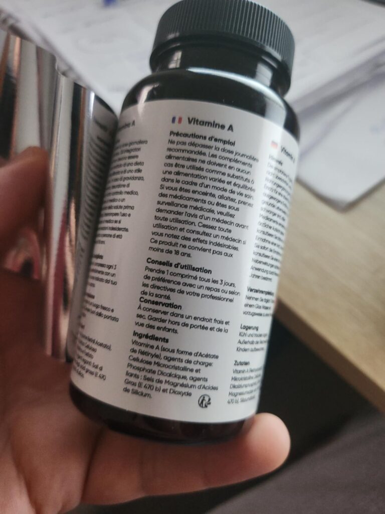 Gros plan sur le côté du flacon, avec les informations de dosage et les mentions légales en français. Le texte est enroulé su...