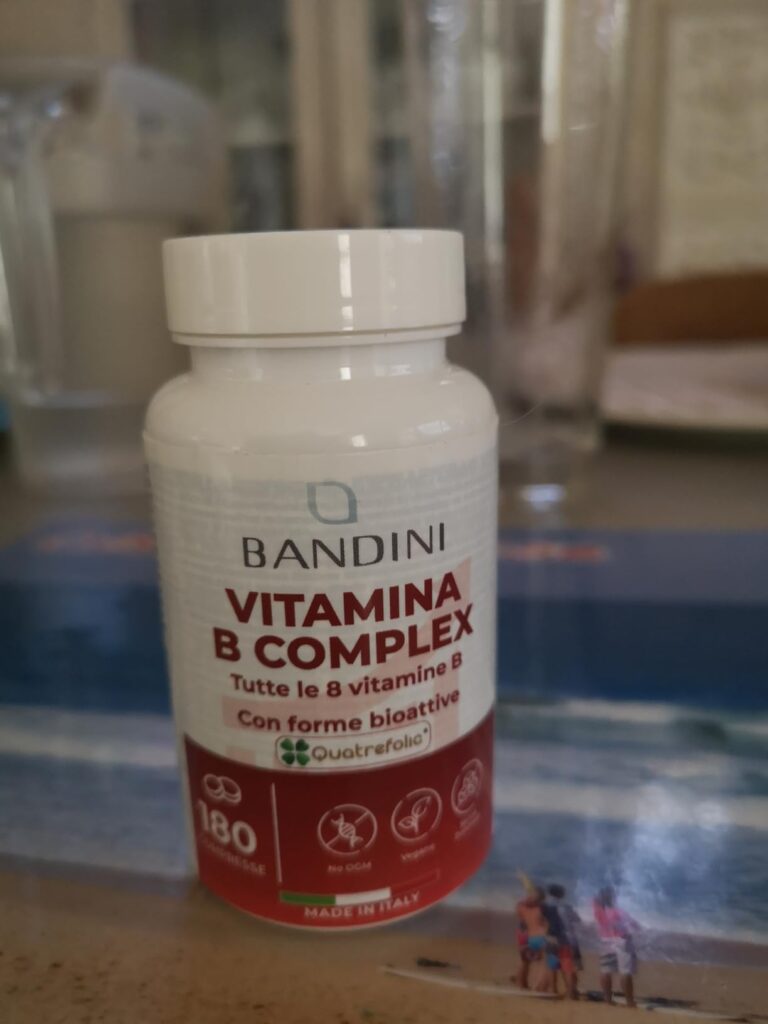 Flacon de vitamine B-complex de la marque Bandini, posé sur une table.
