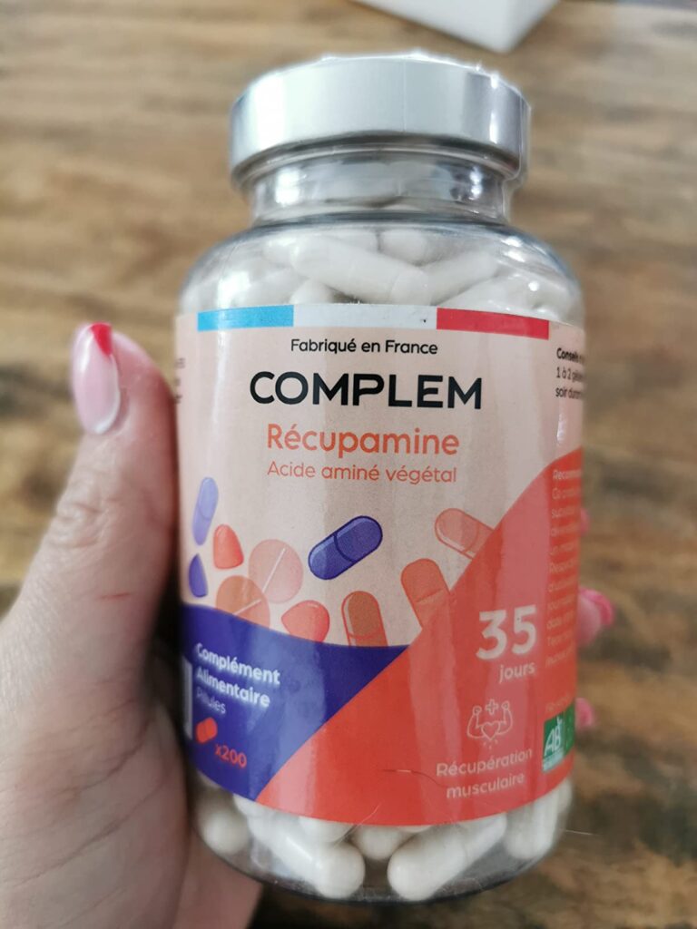 Bouteille de compléments alimentaires COMPLEM Récupamine, tenue dans une main, vue de face.
