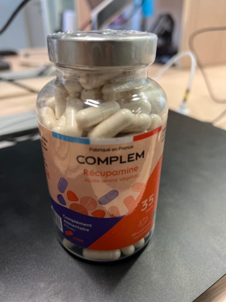 Bouteille de compléments alimentaires COMPLEM Récupamine, vue de face sur un bureau.